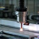 A machine cutting a piece of aluminum for a door frame